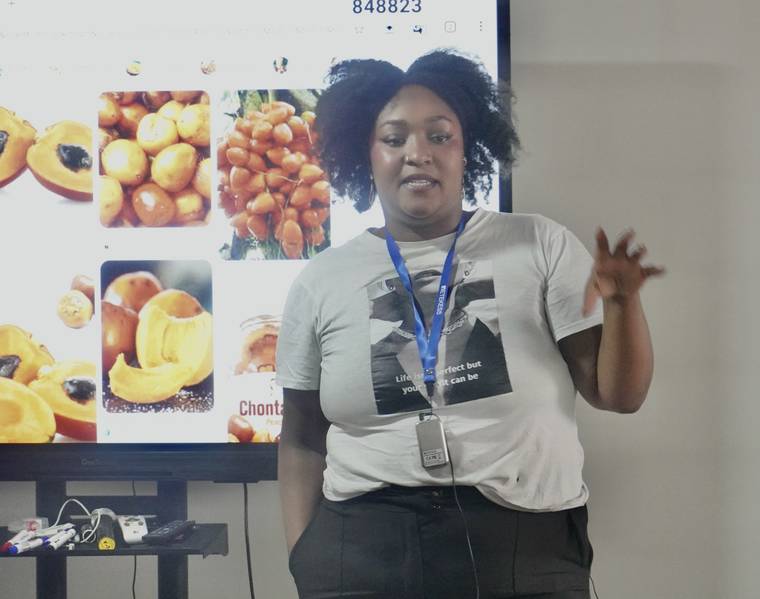Karen Aponzo expone sobre productos de las economías propias del Pacífico, con el chontaduro en pantalla.