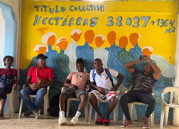 Mural pintado con la cifra del título colectivo de 38.037 hectáreas y siluetas de la comunidad.